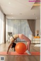 A woman doing a yoga pose on an exercise ball.