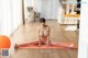 A woman sitting on a yoga mat in a living room.