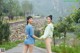 A couple of women standing next to each other on a road.