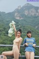 A couple of women standing next to each other on a bridge.