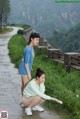 A couple of women standing next to each other on a road.