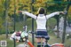 A woman standing next to a bike with her arms outstretched.