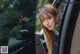 A woman with long hair is looking out the window of a car.