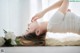 A woman laying on the floor with her hands on her face.