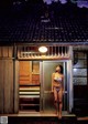 A woman in a bikini standing in the doorway of a house.