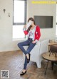 A woman sitting on a white chair holding a cell phone.