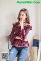 a woman sitting on top of a chair next to a wall