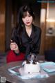 A woman sitting at a table with a birthday cake.