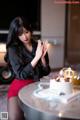 A woman sitting at a table with a birthday cake.