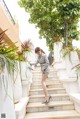 A woman in a gray suit is walking up some stairs.