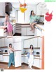 A woman standing in a kitchen next to a refrigerator.