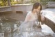 A woman in a white dress sitting in a pool of water.