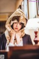 A woman in a fur hat sitting at a table.