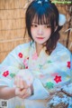 A woman in a kimono holding a basket of flowers.