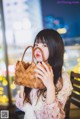 A woman holding a basket in front of her face.