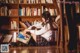 A woman sitting on the floor reading a book.