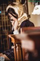 A woman sitting at a table with her chin resting on her hand.