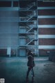 A woman standing in front of a tall building.