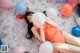 A woman laying on a bed with balloons around her.