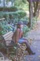 A woman sitting on a bench in a park.