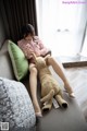 A woman sitting on a couch with a teddy bear.