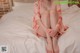 A woman sitting on a bed with her legs crossed.