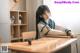 A woman sitting at a desk in a classroom.