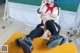 A woman in a school uniform is sitting on a yellow mat.