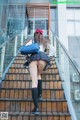 A woman in a school uniform is walking up some stairs.