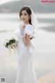 A woman in a wedding dress holding a bouquet of flowers.