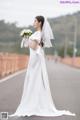 A woman in a wedding dress holding a bouquet of flowers.