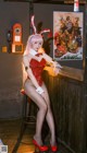 A woman in a bunny costume sitting at a bar.