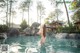 A woman in a white bikini standing in a pool.