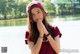 A young woman in a red shirt and a red hat.