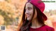 A woman wearing a red hat smiles at the camera.