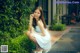 A woman in a white dress sitting on the ground.