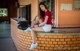 A woman sitting on a brick wall with her legs crossed.