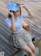 A woman sitting on a wooden dock holding a book.