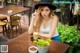 A woman sitting at a table with a cup of coffee.