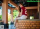 A woman sitting on top of a brick wall.