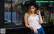 A woman leaning against a window in front of a coffee shop.