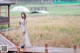 A woman standing on a wooden bridge holding an umbrella.