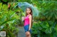 A woman standing in the rain holding an umbrella.