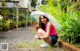 A woman crouching down with an umbrella in the rain.