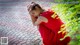 A woman in a red dress sitting on the ground.