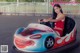 A woman in a red and white dress driving a bumper car.