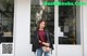 A woman standing in front of a glass door.