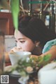 A woman sitting at a table with a cup of coffee.