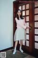 A woman standing in front of a wooden door.