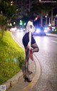 A woman in a police uniform is standing on the side of the road.